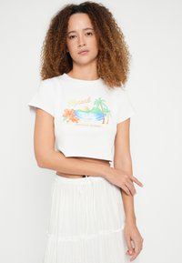 Witte cropped T-shirt met een kleurrijke strandscène afbeelding met palmbomen en bloemen, gemaakt van zachte stof met een losse pasvorm.