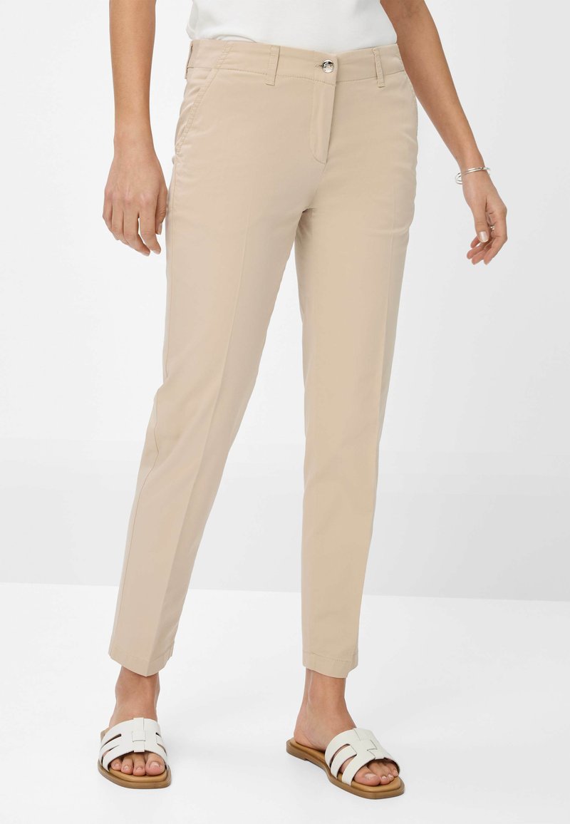 Beige broeken met een slim fit, voorzien van zijzakken, een metalen knoopsluiting en omgeslagen boorden. Draag ze met witte slidesandalen.