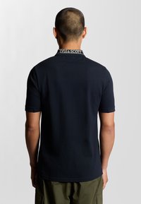 Polo shirt navy con colletto, caratterizzato dal marchio bianco "LYLE & SCOTT". Maniche corte e design liscio e aderente.