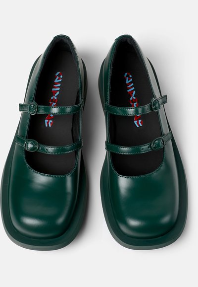 Green patent leather Mary Jane shoes with two adjustable straps. Rounded toe design, cushioned insole, and smooth finish. Flat sole.