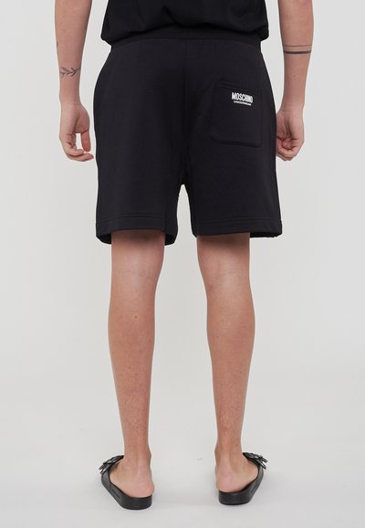 Shorts neri in cotone con una vestibilità rilassata, dotati di tasca posteriore e logo "Moschino Underwear" in bianco. Texture liscia e bordi orlati.