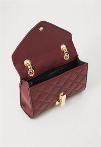Borsa in pelle borgogna con texture trapuntata, hardware dorato, chiusura magnetica e una tasca con zip interna.