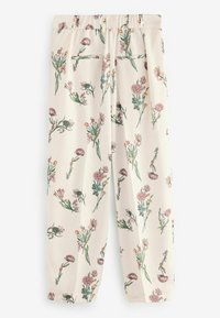 Crèmekleurige broek met bloemenpatroon en elastische tailleband, met een mix van roze en gele bloemen en groene stelen.