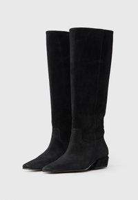 Botas de gamuza negras hasta la rodilla con punta afilada y tacón bloque bajo. Presentan una textura suave y un diseño elegante y minimalista.