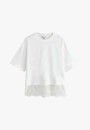 Fehér rövid ujjú póló díszes csipkés alsó szegéllyel. Puha anyagú, kényelmes szabású, kerek nyakkivágással.