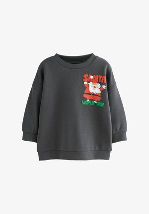 Sweatshirt gris avec un col rond, coupe ample et poignets côtelés. Présente un design imprimé de Santa et le texte "TOUR DU MONDE DE SANTA" en rouge et vert.
