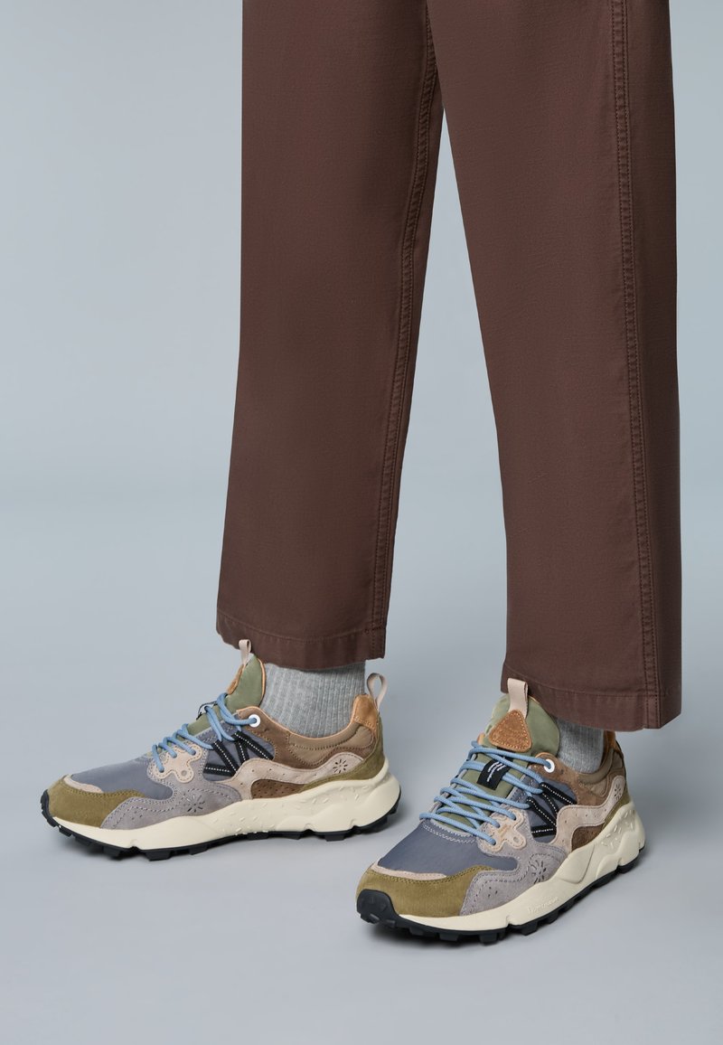 Sportliche Sneaker in Grau-, Grün- und Beigetönen; verfügen über strukturiertes Wildleder und Mesh, Schnürdesign und eine robuste weiße Außensohle mit Profil.