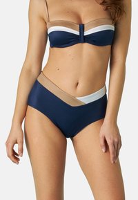 Completo bikini con top blu navy decorato con accenti beige e bianchi. Parte inferiore alta blu navy con blocchi di colore asimmetrici e superficie liscia.