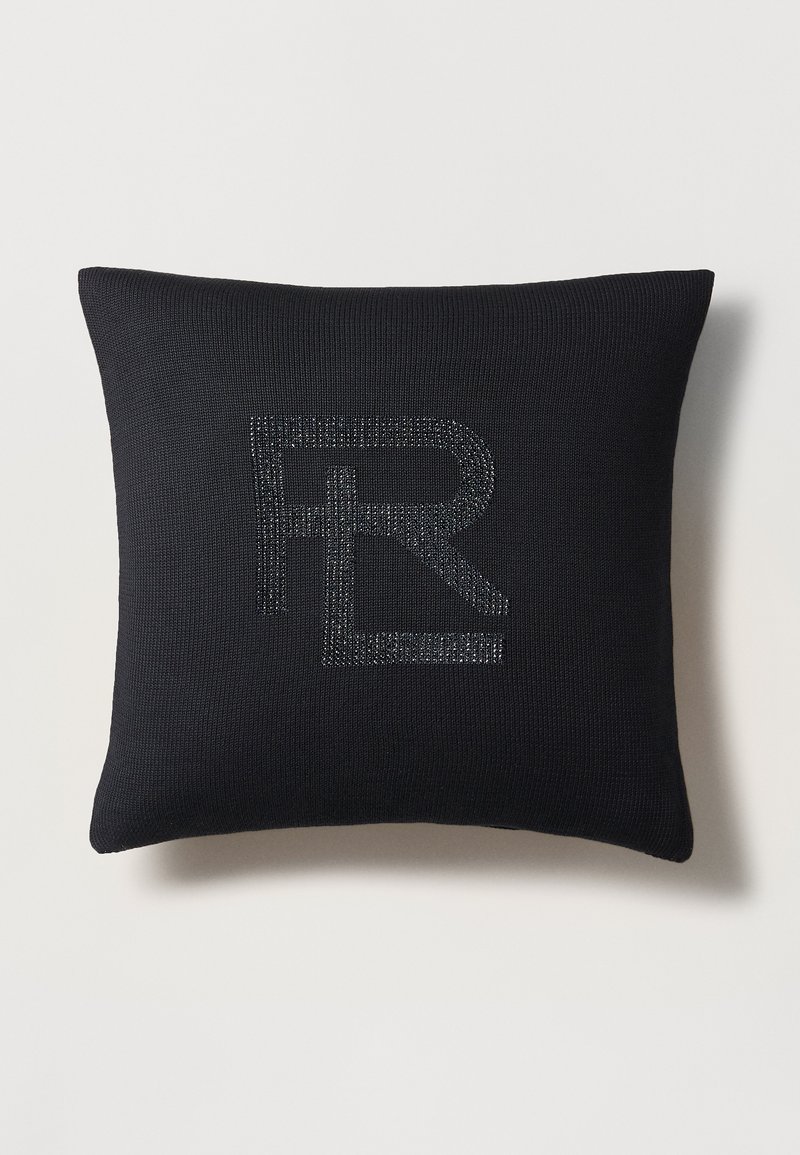 Crna jastučić s teksturiranim pletenim dizajnom i srebrnim metalik "R" logom utisnutim s jedne strane. Mekan i pravokutni oblik.