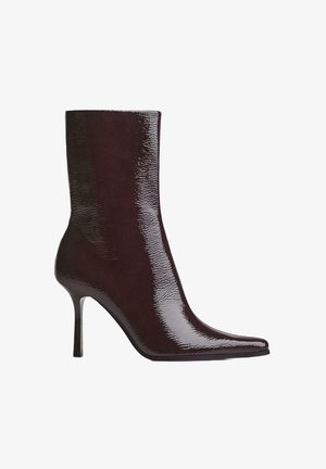 Burgundy ankle boot with glossy finish, pointed toe, and thin high heel. Sleek design showcases smooth texture and streamlined silhouette.