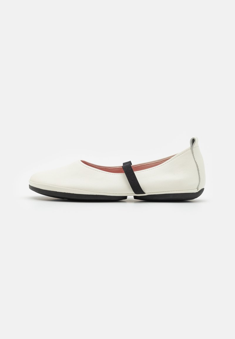 Ballerines en cuir blanc avec une bride élastique noire, bout rond, profil fin et semelle noire texturée. Design minimaliste, sans motifs visibles.
