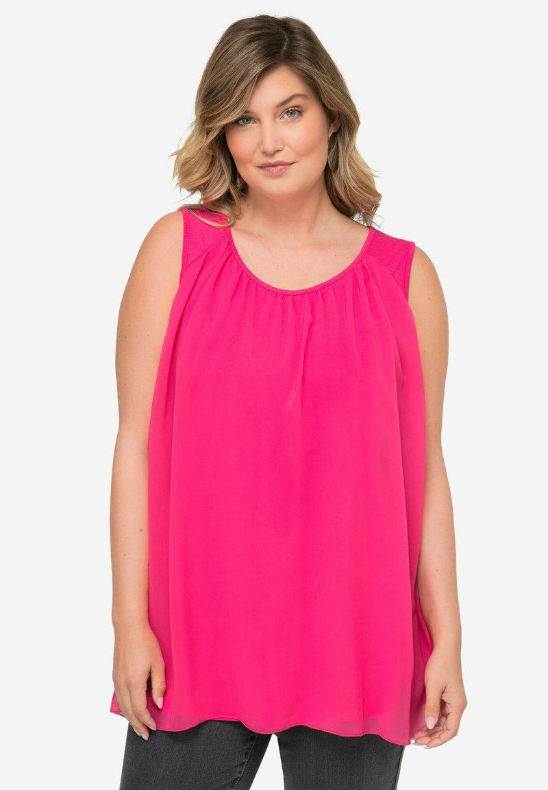 Top ampio senza maniche di colore rosa brillante, realizzato in tessuto leggero. Presenta un collo rotondo e dettagli arricciati per un volume maggiore.