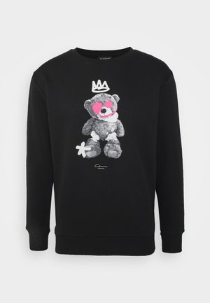 Sweat-shirt noir présentant un graphique d'ours en peluche flou avec des accents roses et une couronne. Confectionné dans un tissu doux et texturé avec des poignets côtelés.
