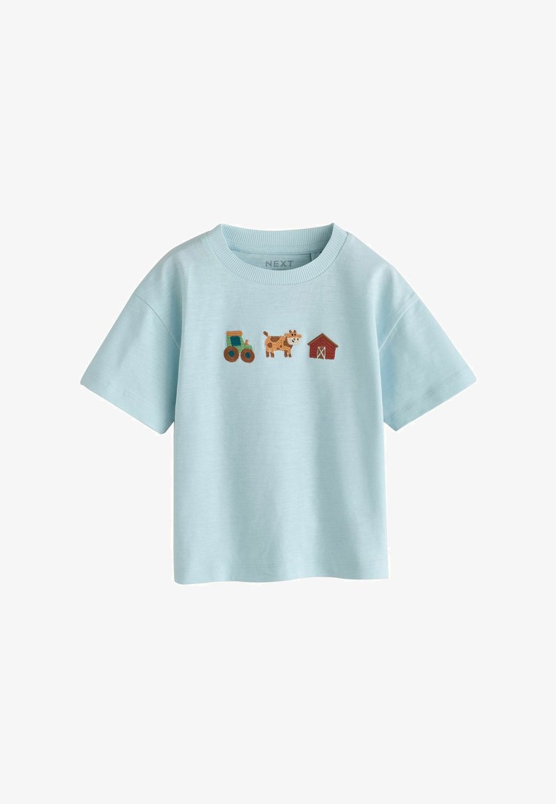 T-shirt enfant bleu clair avec des icônes brodées de tracteur, de vache et de grange rouge centrées sur la poitrine.