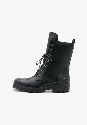 Mustat nahkaiset nilkkurit nauhoilla, niitteillä varustetut sivuilla, teksturoidut varvastossut ja karkeat pohjat pidon parantamiseksi.