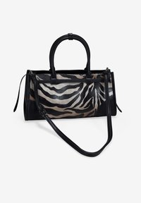 Bolso de mano de estampado de cebra en negro y beige, con dos asas superiores y una correa de hombro removible. Presenta un cierre de cremallera y detalles en cuero.