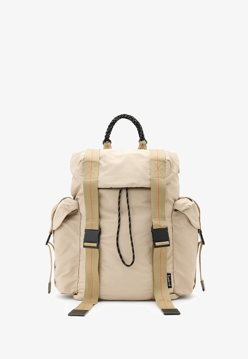 Zaino in tessuto beige con chiusura arrotolata, spallacci regolabili in nylon, tasche frontali e manico intrecciato. Presenta cuciture a contrasto.