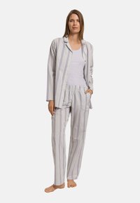 Gestreepte pyjama-set met een knoopsluiting shirt en broek met elastische tailleband in zachte stof. De kleuren zijn wit, paars en lichtgroen.