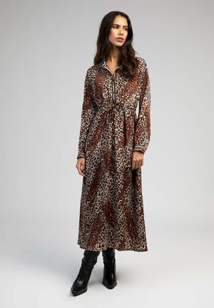 Robe maxi léopard à longues manches, devant boutonné et taille cintrée. Présente des tons marron et beige avec des accents noirs.