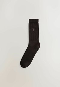 Sorte ribbede sokker med en komfortabel kant og en lille lilla logo-detalje. Fremstillet af blødt stof, har de et klassisk design.
