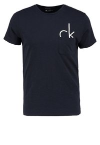 Námořnická modrá bavlněná trička s kulatým výstřihem, krátkými rukávy a přední kapsou s bílým logem. Měkká struktura, casual design.