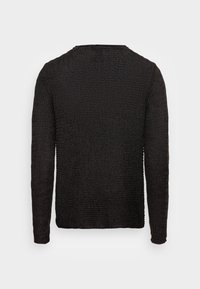 Pull à manches longues en maille noire texturée, avec un col rond et des poignets côtelés, coupe droite et design décontracté.