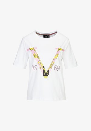 Weißes Baumwoll-T-Shirt mit einem großen pinken "V" mit goldener Kette und schwarzen Akzenten sowie dem Jahr "1969" in lila darunter. Kurzarm.