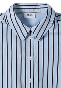 Chemise bleu clair boutonnée avec des rayures verticales bleu marine et blanches et un col pointu, étiquetée "CECIL" à l'intérieur de l'encolure.