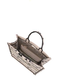 Borsa in tela con accenti neri, caratterizzata da motivi floreali e scritte. Include una tasca interna con cerniera e due manici per il trasporto.