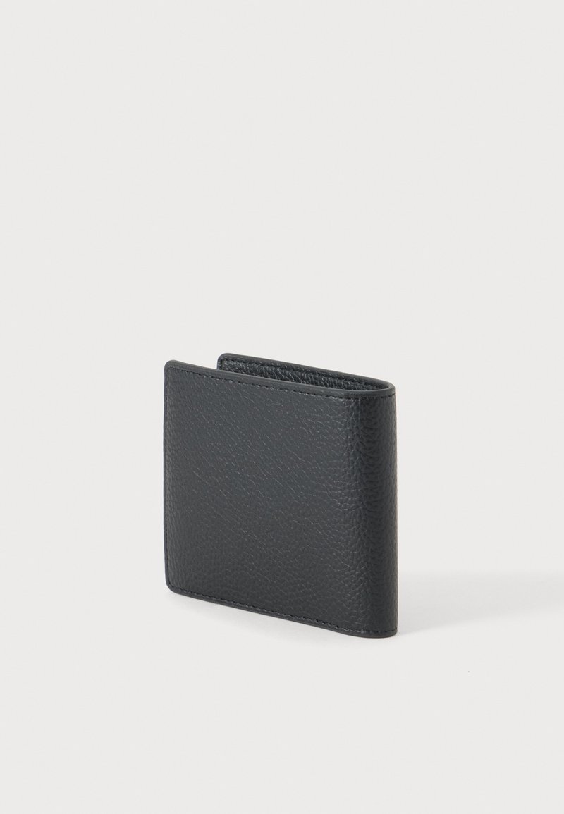 Portafoglio bifold in pelle nera struttura, chiuso in piedi su uno sfondo grigio chiaro uniforme.