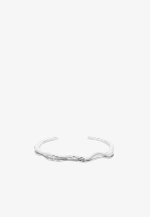 Bracelet manchette ouvert en argent avec un design ondulé lisse et irrégulier et une finition polie sur fond blanc.