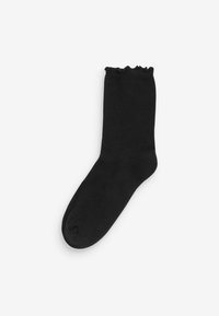 Svart ankelsocka med mjuk textur och volangkant. Designad i en enkel, enfärgad stil med en klassisk form.