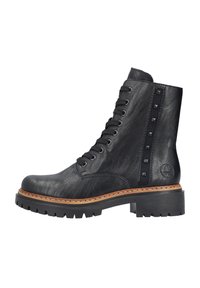 Bottine en cuir noir avec des lacets sur le devant, des clous le long du côté et une semelle en caoutchouc noir épaisse. Présente une semelle intermédiaire beige cousue.