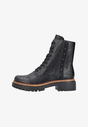 Zwarte leren enkelboot met vetersluiting aan de voorkant, opvallende studs langs de zijkant en een chunky zwarte rubberen zool. Heeft een gestikte tan tussenzool.