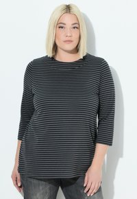Schwarz- und grau gestreifte langärmlige Bluse mit rundem Ausschnitt, weichem Baumwollmaterial und lockerer Passform. Kombiniert mit dunklen Jeans.