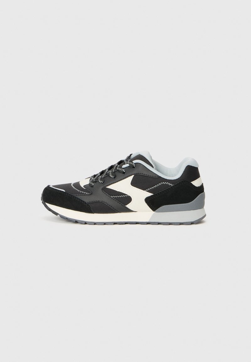 Schwarze und graue Sneakers mit einem Mix aus Materialien, darunter Wildleder und Mesh, einer strukturierten Sohle und kontrastierenden weißen Akzenten.