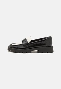 Black and white leather loafers with a textured upper, rounded toe, and chunky black rubber sole featuring a tread pattern.