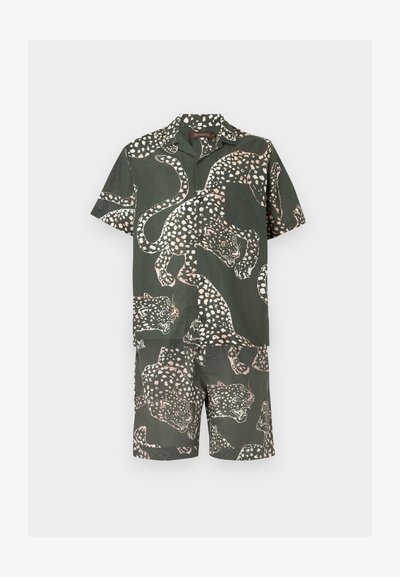 Σκούρο πράσινο μπλουζάκι με κοντά μανίκια και ταιριαστό σορτς με μοτίβο λεοπάρδαλης σε ανοιχτό ροζ και λευκές κηλίδες.