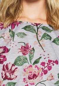 Blumenmusterstoff in verschiedenen Schattierungen von Lila, Rosa und Grün auf einem hellgrauen Hintergrund; enthält verschiedene Blatt- und Blumendesigns.