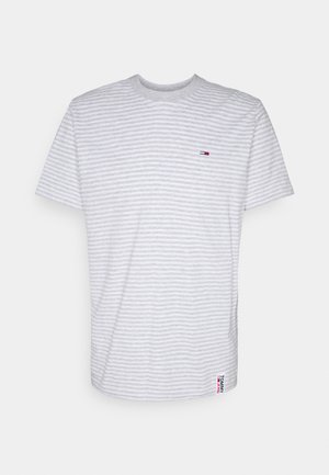 Biały T-shirt z krótkim rękawem z cienkimi jasnoszarymi poziomymi paskami, małe czerwono-niebieskie logo na piersi oraz metka Tommy Jeans przy dolnej krawędzi.