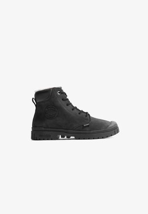 Schwarze Knöchelstiefel aus glattem Leder mit Gummisohle, runder Zehenform, Schnürvorderseite und einem runden Logo-Akzent an der Seite.