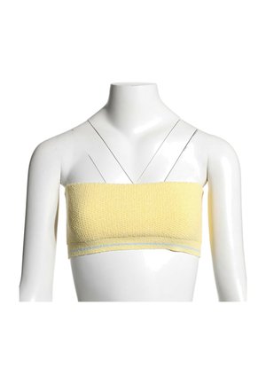 Haut bandeau texturé jaune sur mannequin blanc sans tête avec fines bretelles noires croisées à l’avant.