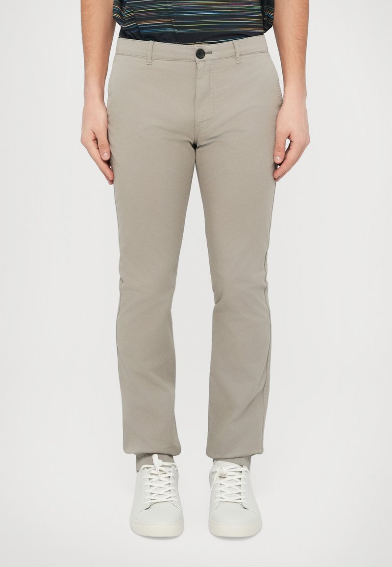 Jasnoszare spodnie o prostych nogawkach z zapięciem na guzik, wykonane z gładkiego materiału. Stylizowane z białymi trampkami. Prosty i uniwersalny design.