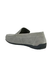 Scarpa slip-on in suede grigio con profilo basso, punta arrotondata e suola in gomma nera. Presenta un accento cucito lungo la tomaia.