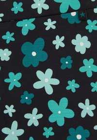 Crna tkanina sa raštrkanim tirkiznim i svijetloplavim cvjetovima s pet latica, svaki s malim bijelim središtem, te mali crni tag s tirkiznom zvijezdom.