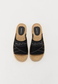Pantofi negri din pânză cu talpă din jută împletită, având logo-ul "VALENTINO" și detalii de cusătură geometrică. Design plat, tip slip-on.