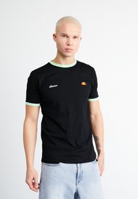 Black T-shirt with mint green ribbed neckline and sleeves. Features a small embroidered logo and design on the chest. Soft cotton material.
