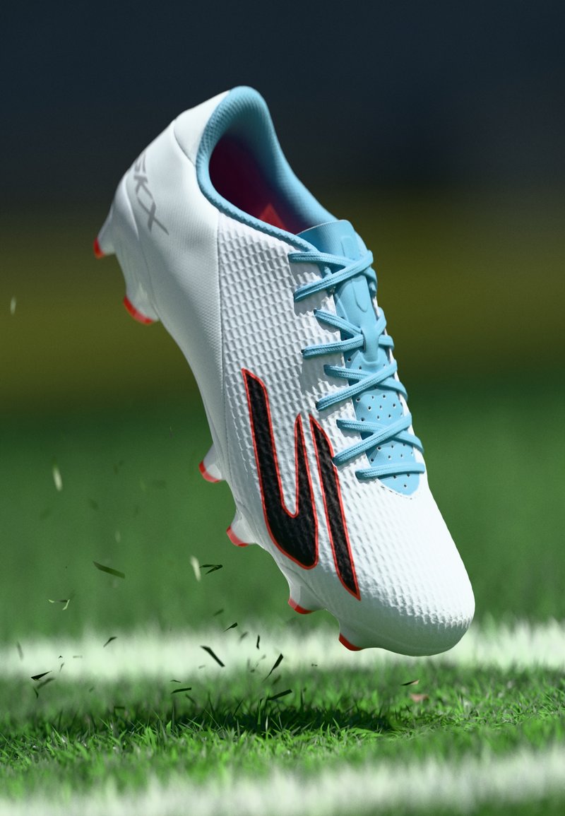 Bota de futebol branca com um upper texturizado, atacadores azuis, logotipo preto, detalhes vermelhos e sola com bom grip, suspensa acima da relva.