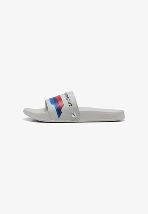 Gray slide sandal with a wide strap featuring red and blue diagonal stripes. Accented with a logo and rounded toe design. Smooth texture.