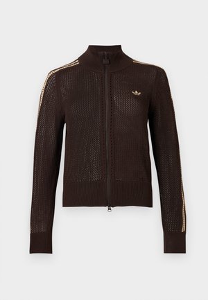 Veste zippée en tricot marron foncé avec des rayures beiges sur les manches et un petit logo trèfle Adidas beige sur le côté gauche de la poitrine.